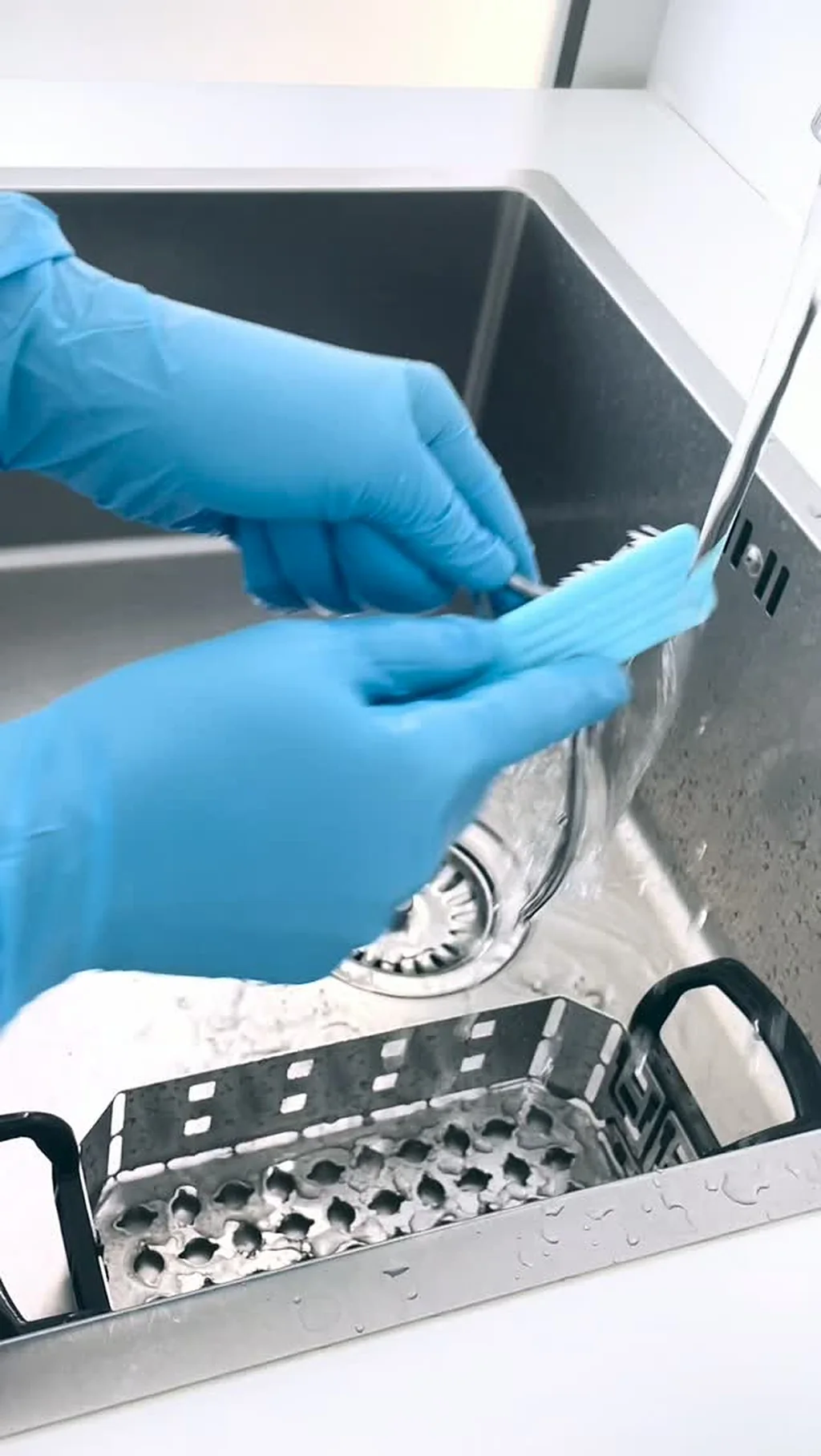 Instruments being cleaned by hand in gloves before sterilisation